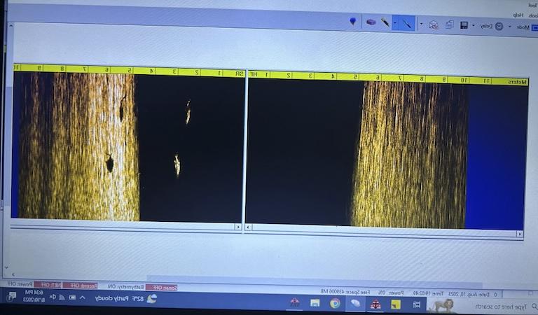 On a computer screen, two images appear side by side. They are infrared images of the bays seafloor. 